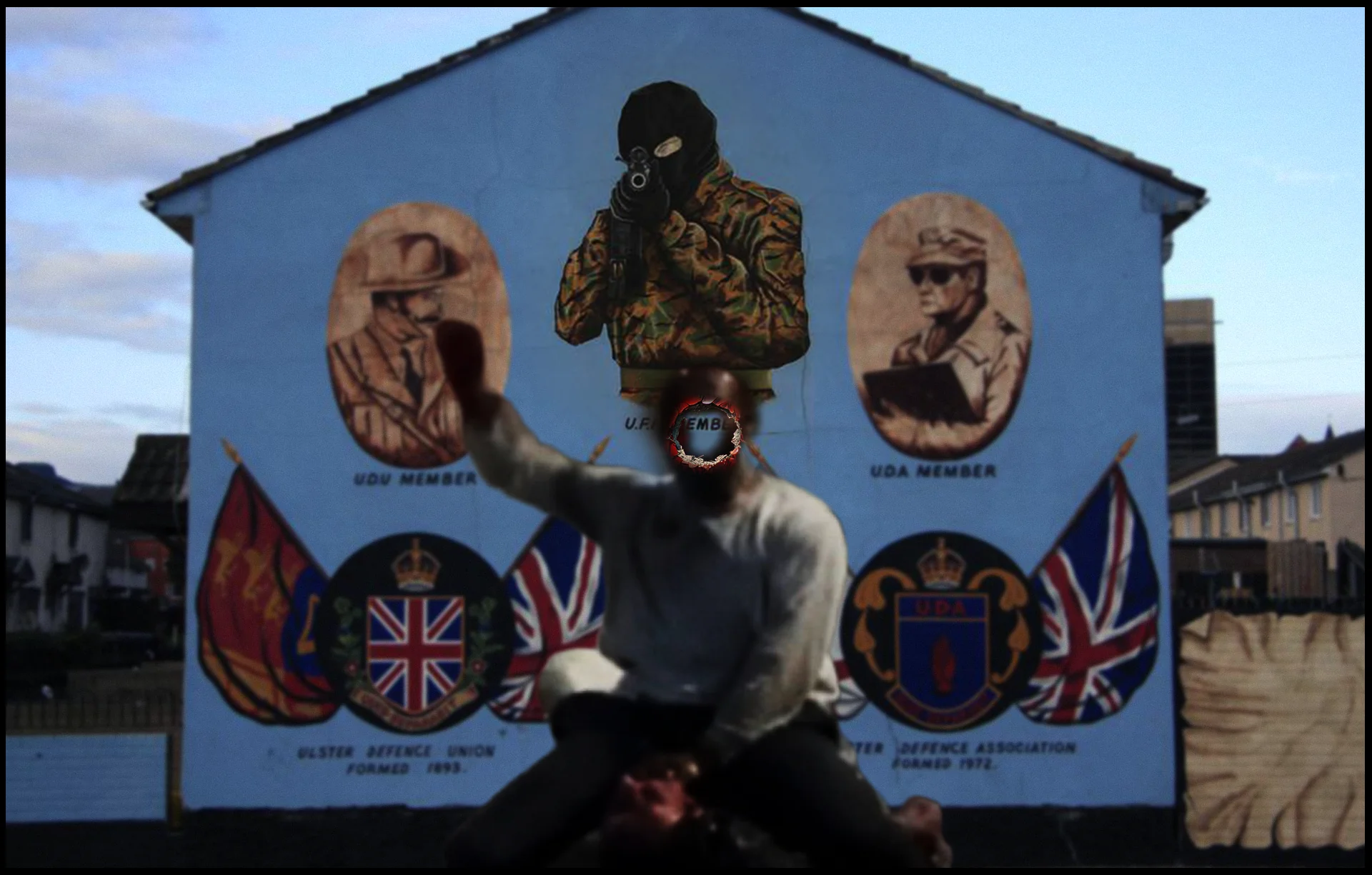 Kneeling shirtless man with fiery halo raised fist, superimposed over Loyalist paramilitary mural in Belfast — UDA, UDU, UFF imagery, Union flags